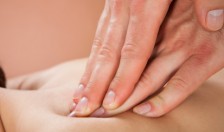 Closeup of male therapist massaging female customer's back at beauty spa